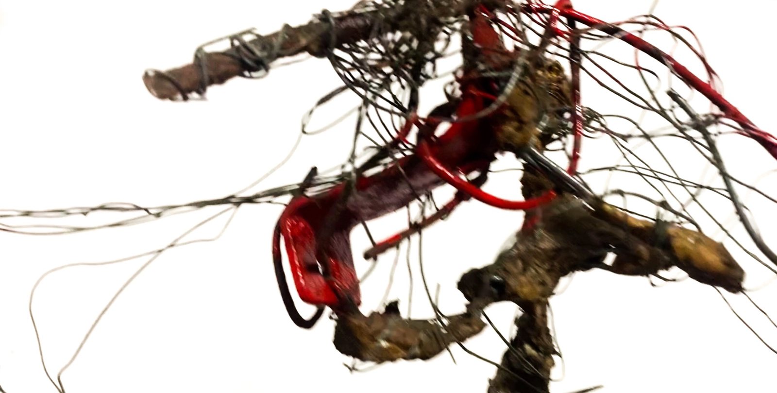 Close view of red wire and found objects in Men at Work